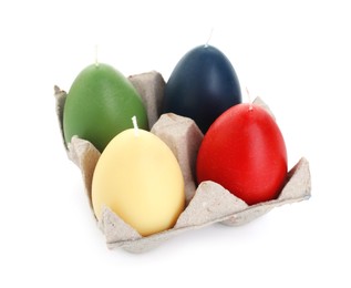 Photo of Colorful egg-shaped candles in carton isolated on white. Easter decor