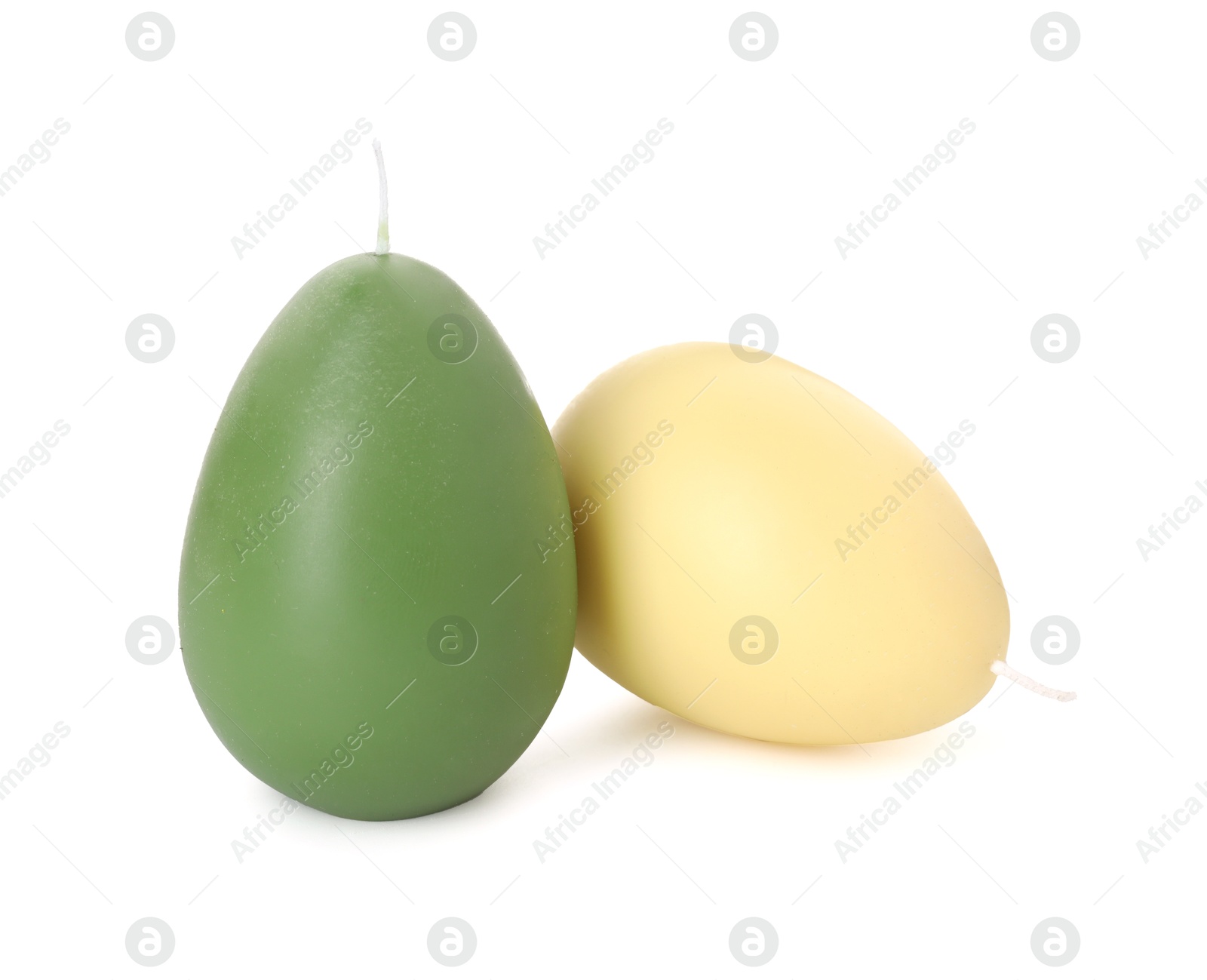 Photo of Colorful egg-shaped candles isolated on white. Easter decor