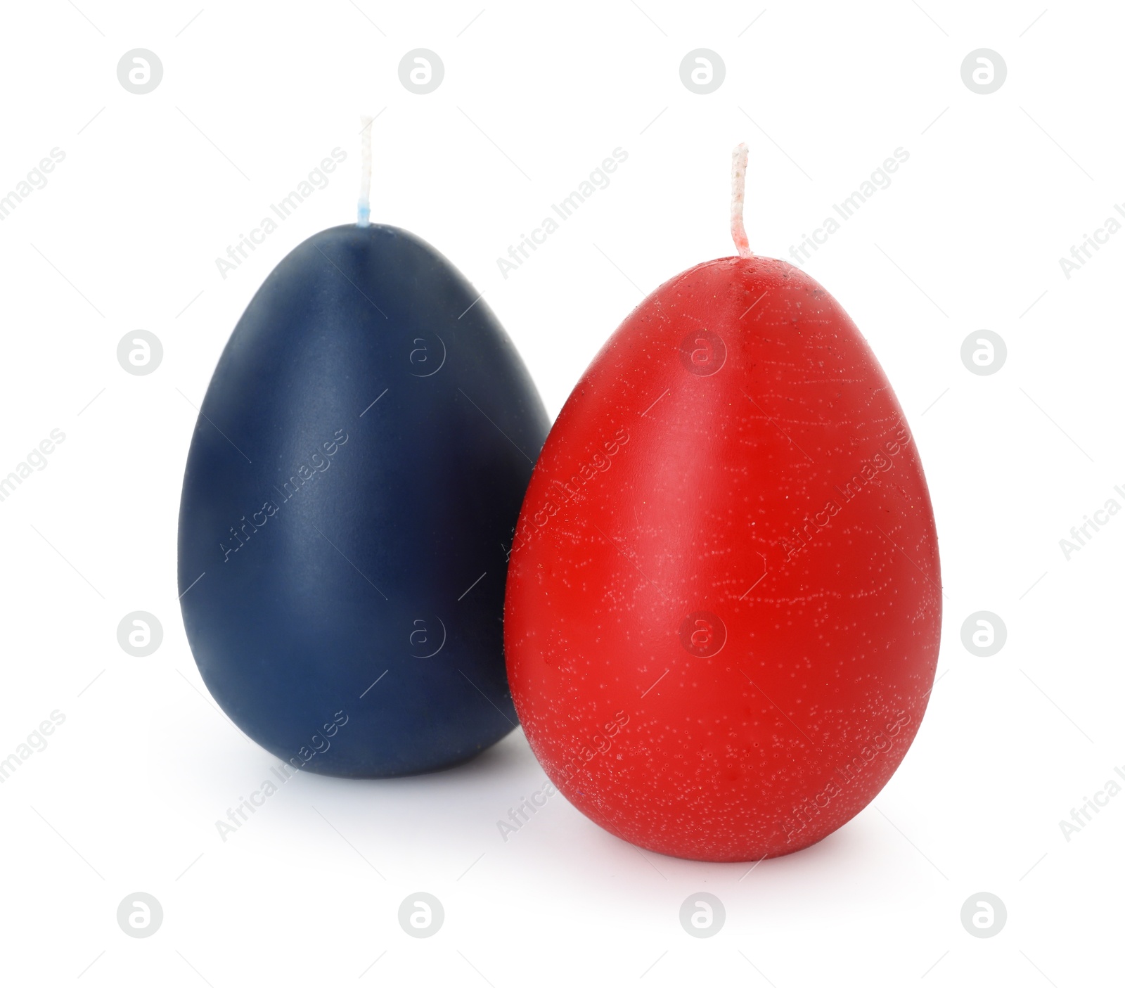 Photo of Colorful egg-shaped candles isolated on white. Easter decor