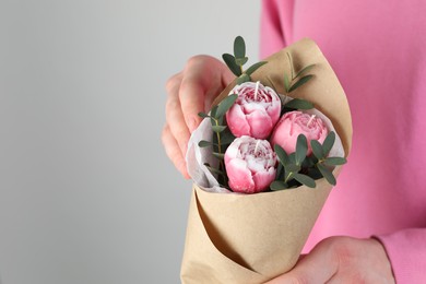 Photo of Woman with bouquet of beautiful flower shaped candles on light background, closeup. Space for text