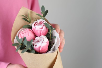 Photo of Woman with bouquet of beautiful flower shaped candles on light background, closeup. Space for text