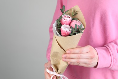 Photo of Woman with bouquet of beautiful flower shaped candles on light background, closeup. Space for text