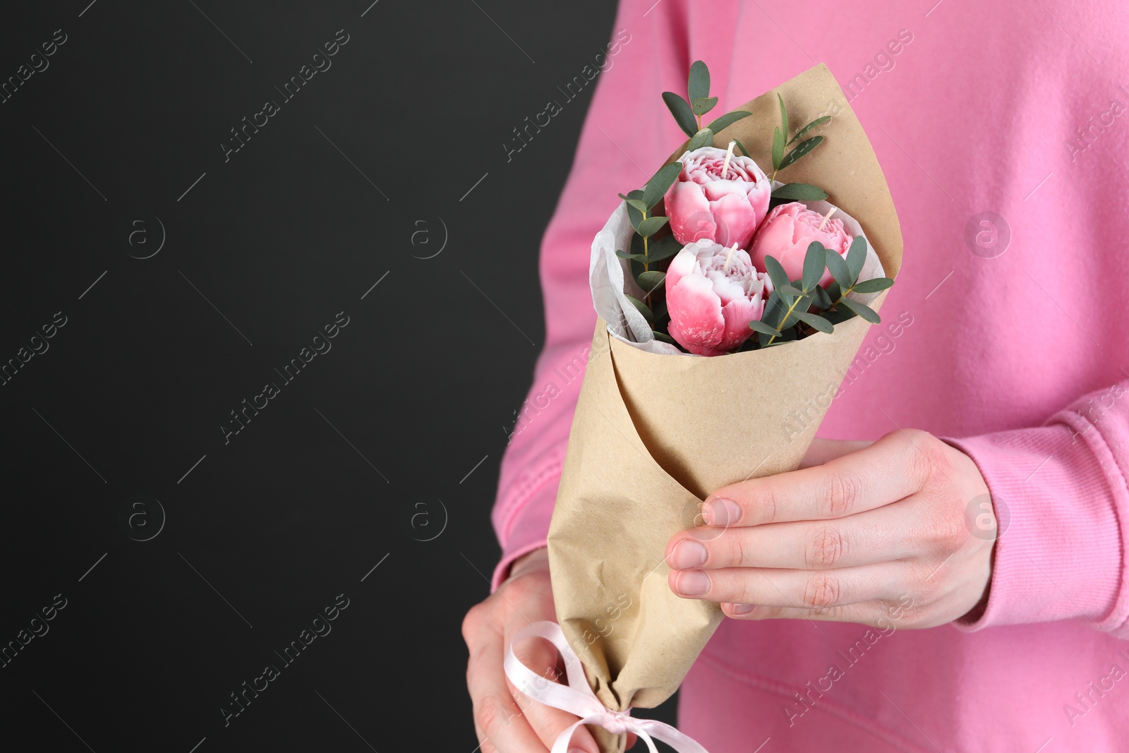 Photo of Woman with bouquet of beautiful flower shaped candles on black background, closeup. Space for text