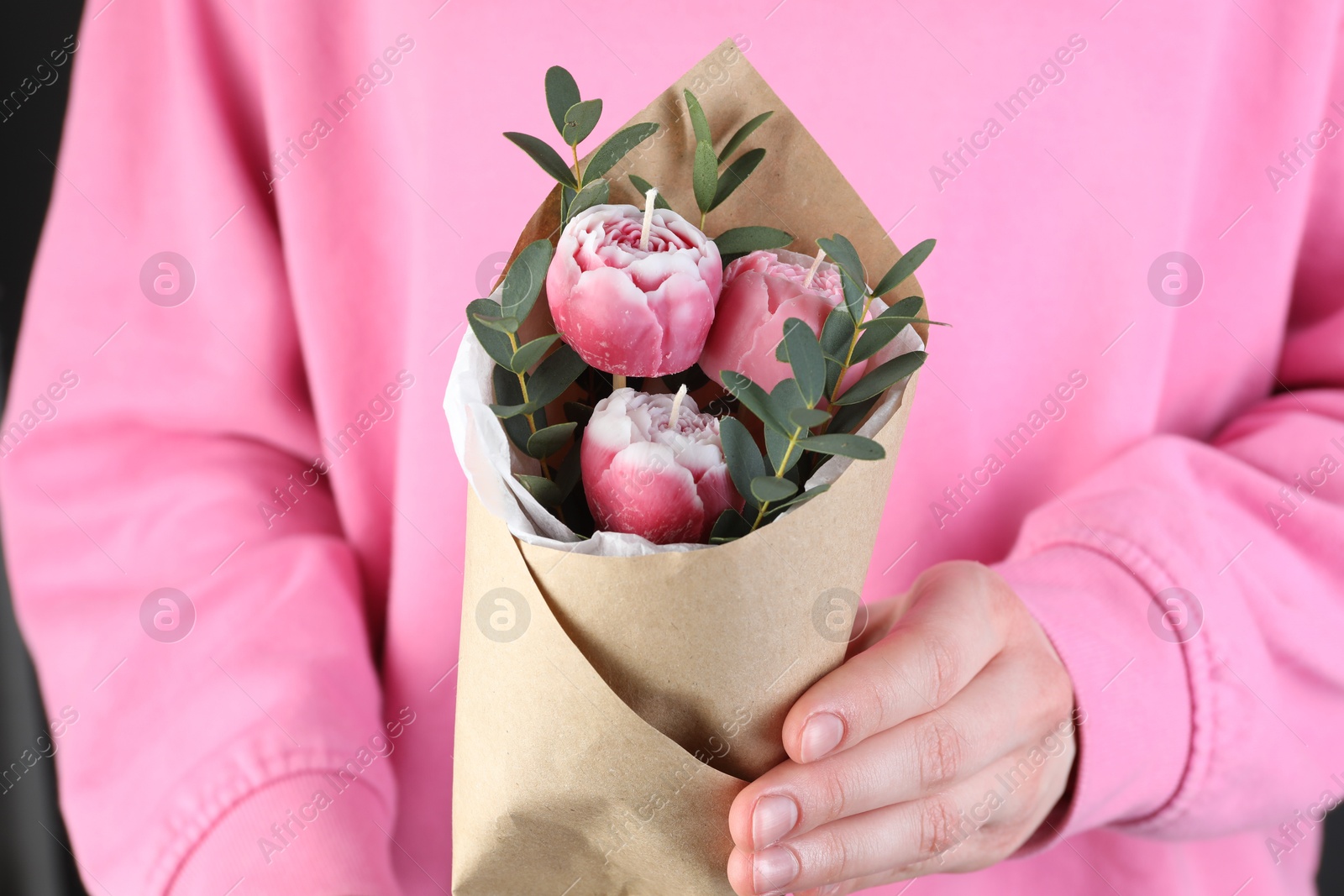 Photo of Woman with bouquet of beautiful flower shaped candles on black background, closeup