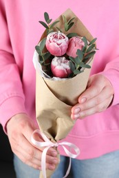 Photo of Woman with bouquet of beautiful flower shaped candles on black background, closeup