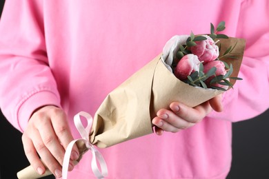 Photo of Woman with bouquet of beautiful flower shaped candles on black background, closeup