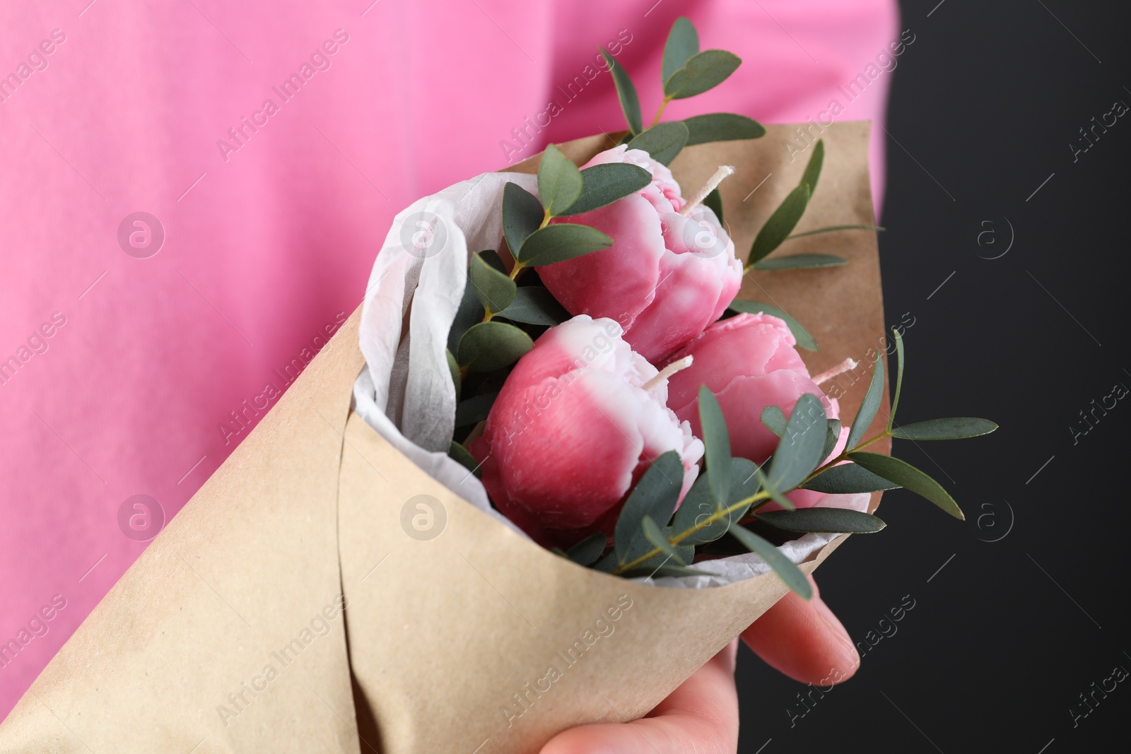 Photo of Woman with bouquet of beautiful flower shaped candles on black background, closeup