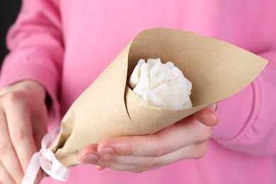 Photo of Woman with beautiful flower shaped candle on black background, closeup