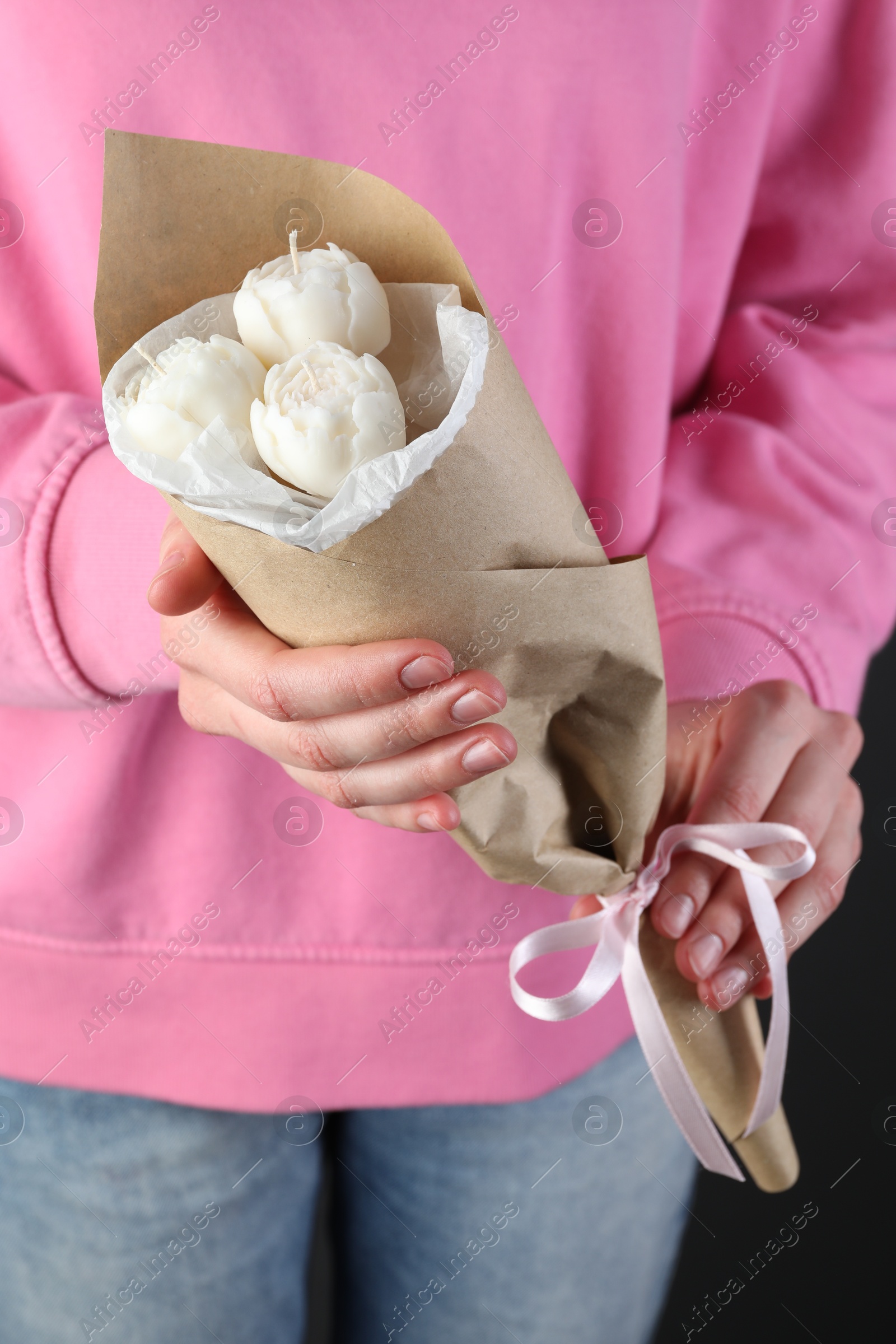 Photo of Woman with bouquet of beautiful flower shaped candles on black background, closeup