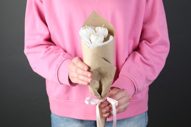 Photo of Woman with bouquet of beautiful flower shaped candles on black background, closeup