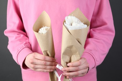 Photo of Woman with beautiful flower shaped candles on black background, closeup