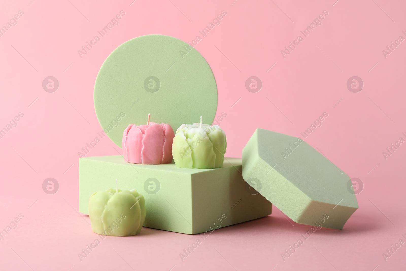 Photo of Beautiful flower shaped candles on pink background