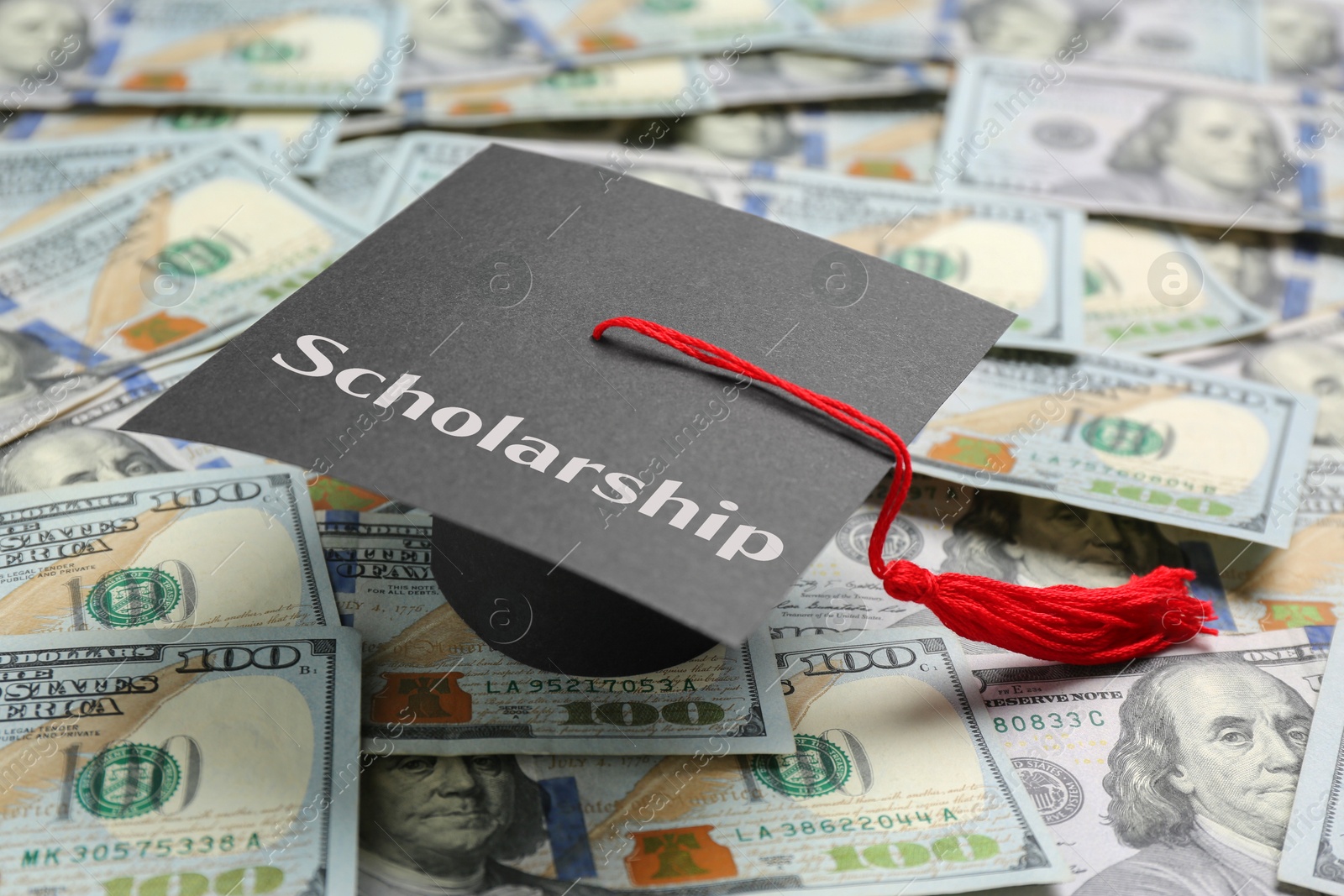 Image of Graduate hat with word Scholarship on banknotes, closeup