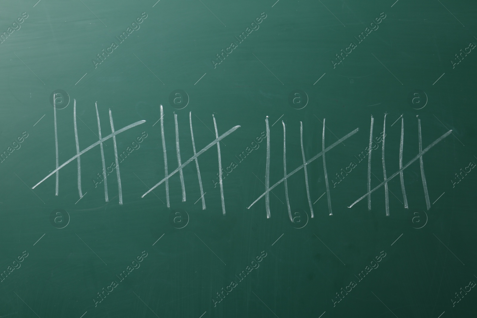 Photo of Counting days by drawing sticks with chalk on chalkboard, closeup