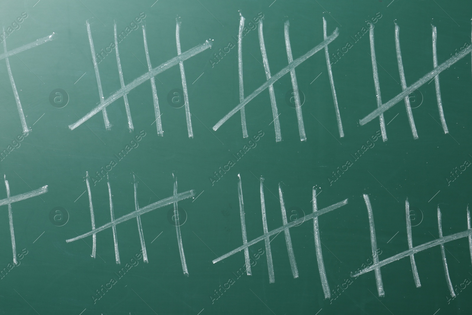 Photo of Counting days by drawing sticks with chalk on chalkboard, closeup