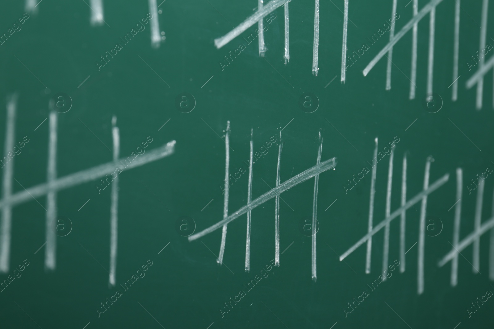 Photo of Counting days by drawing sticks with chalk on chalkboard, closeup