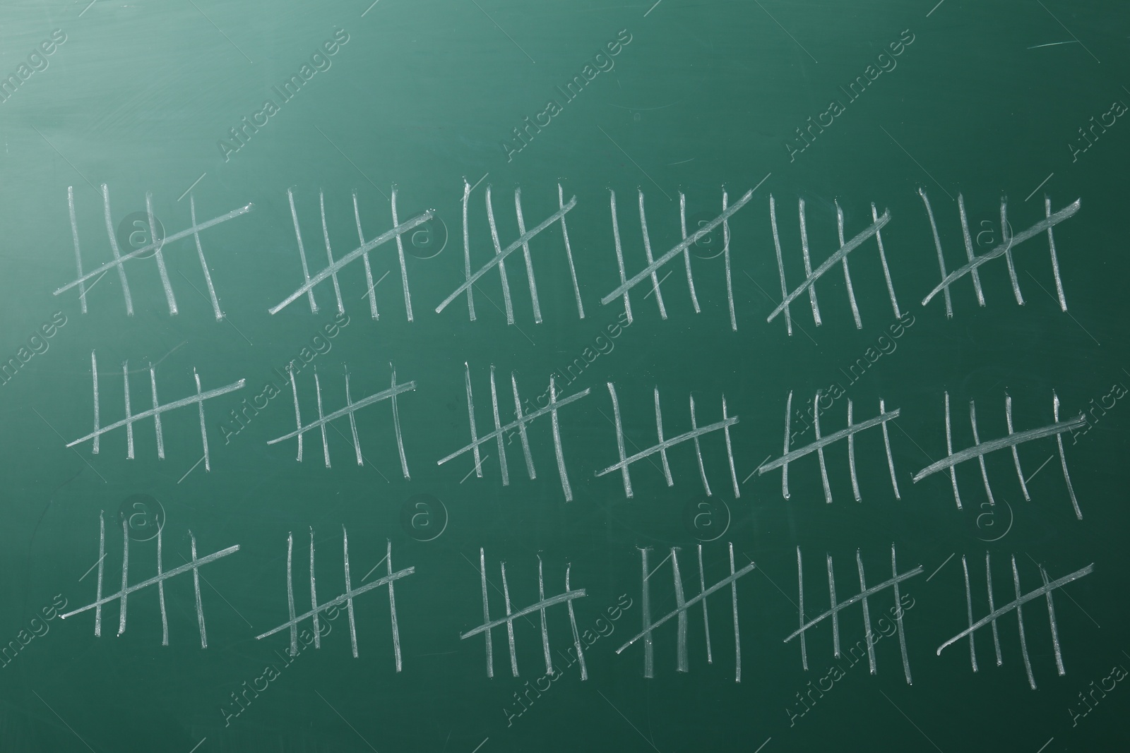 Photo of Counting days by drawing sticks with chalk on chalkboard, closeup