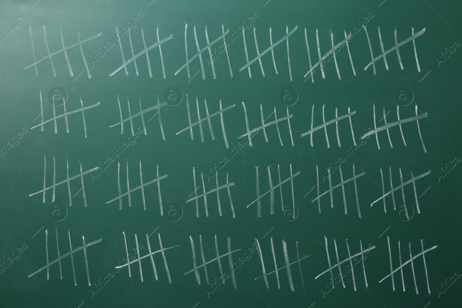 Photo of Counting days by drawing sticks with chalk on chalkboard, closeup