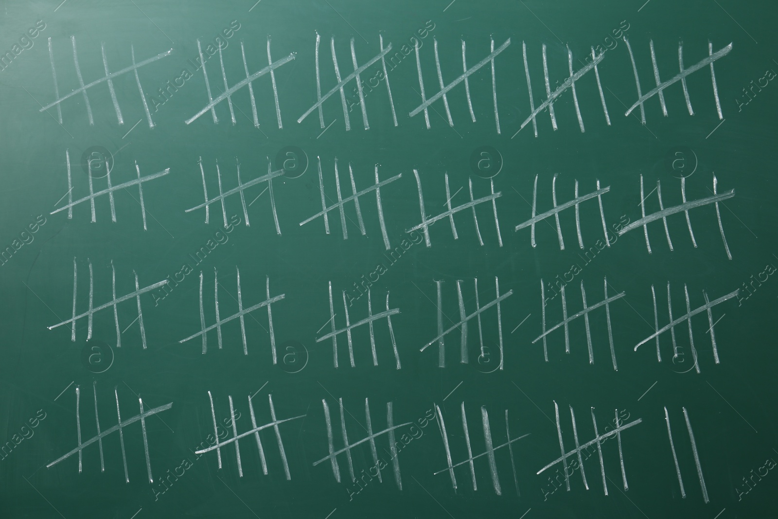 Photo of Counting days by drawing sticks with chalk on chalkboard, closeup