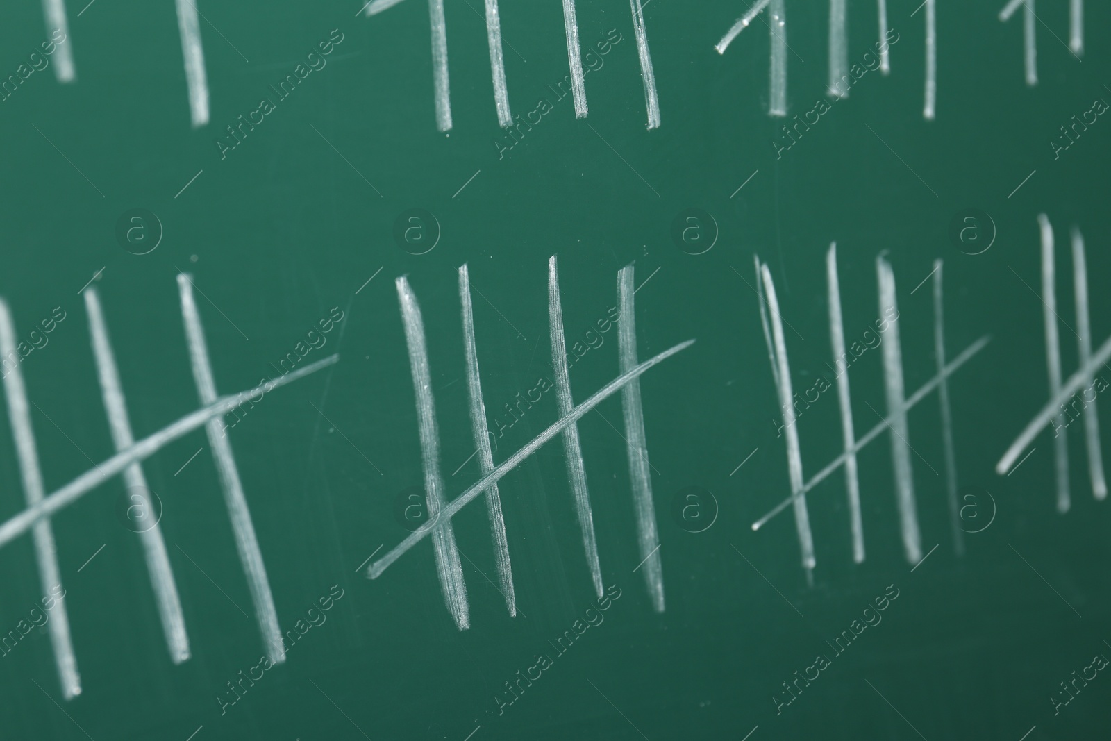 Photo of Counting days by drawing sticks with chalk on chalkboard, closeup