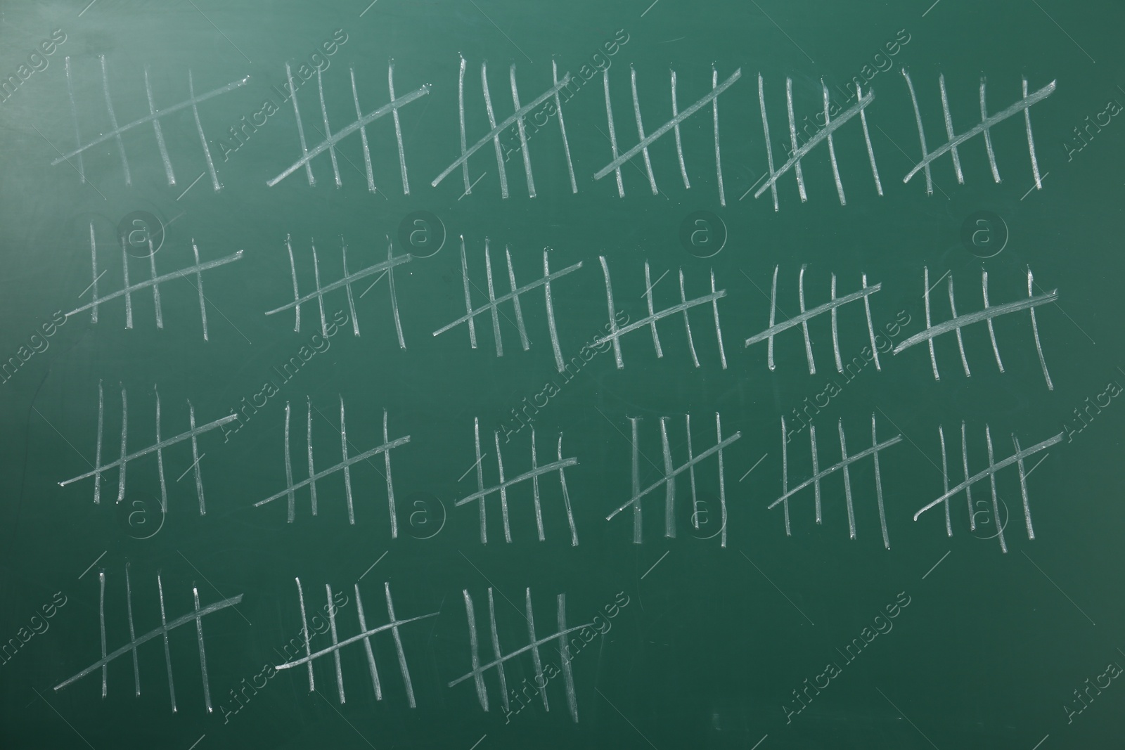 Photo of Counting days by drawing sticks with chalk on chalkboard, closeup