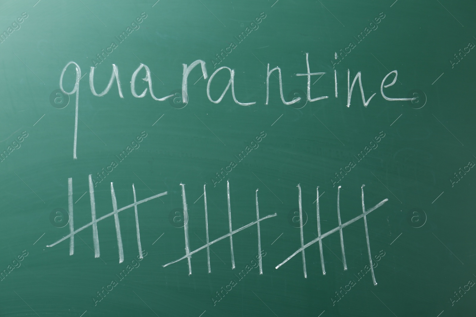 Photo of Counting days by drawing sticks with chalk and word Quarantine on chalkboard, closeup