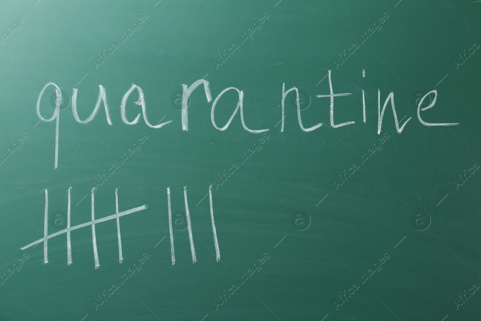 Photo of Counting days by drawing sticks with chalk and word Quarantine on chalkboard, closeup