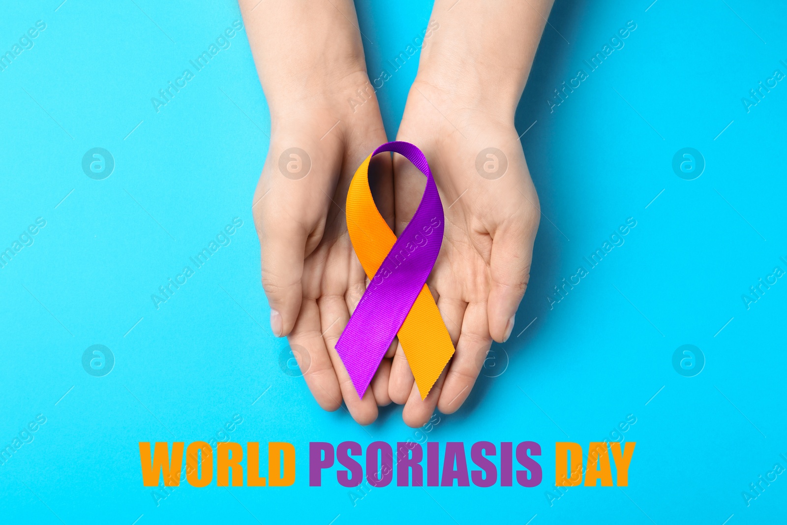 Image of World Psoriasis Day. Woman holding orange-orchid awareness ribbon on light blue background, top view