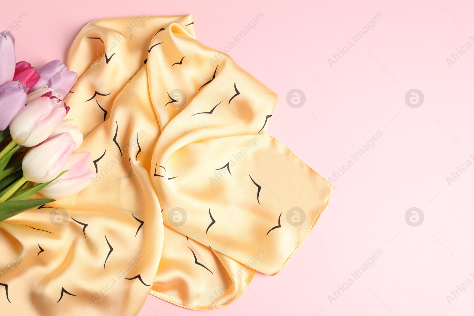 Photo of Beautiful scarf and tulips on light pink background, top view. Space for text