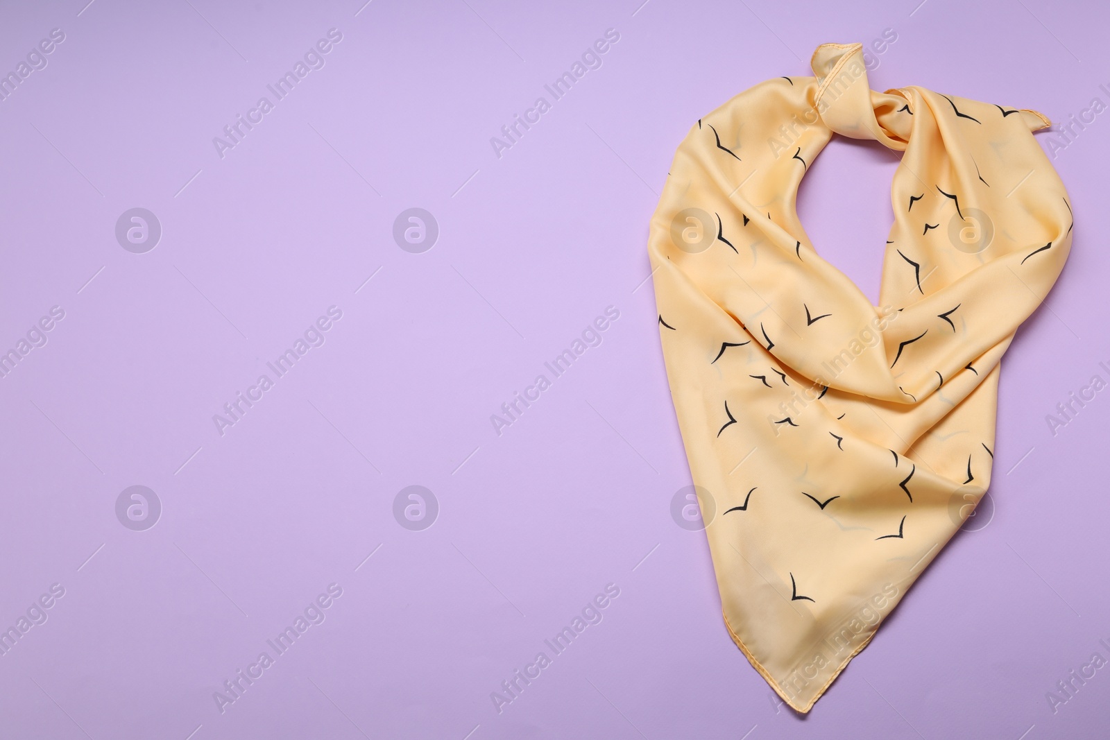 Photo of Beautiful scarf on lilac background, top view. Space for text