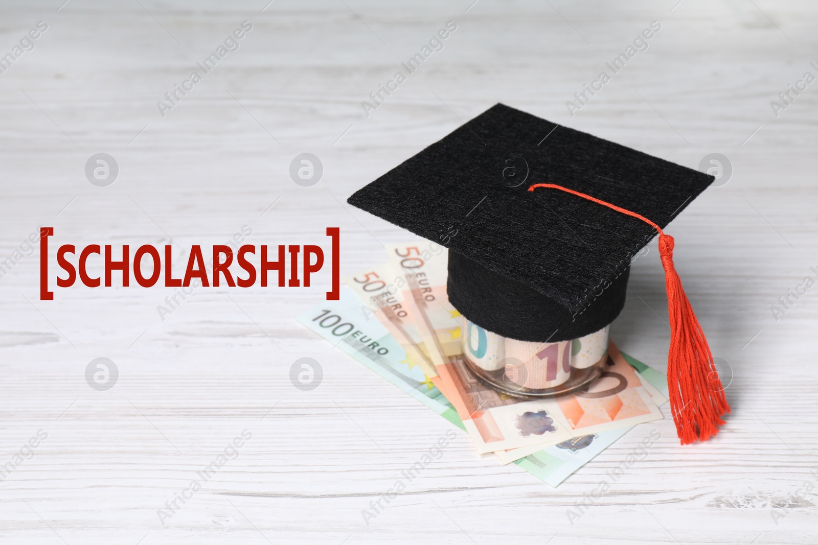 Image of Scholarship. Graduate hat and euro banknotes on white wooden table