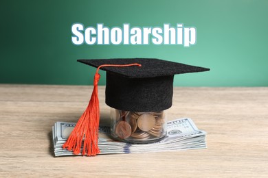 Image of Scholarship. Graduate hat, dollar banknotes and coins on wooden table against green chalkboard