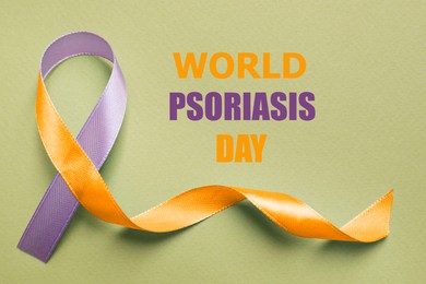 Image of World Psoriasis Day. Orange-orchid awareness ribbon on olive color background, top view