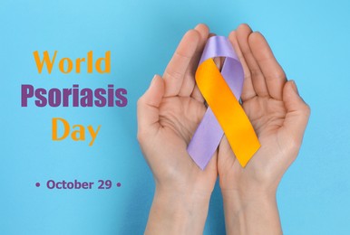 Image of World Psoriasis Day (October, 29). Woman holding orange-orchid awareness ribbon on light blue background, top view