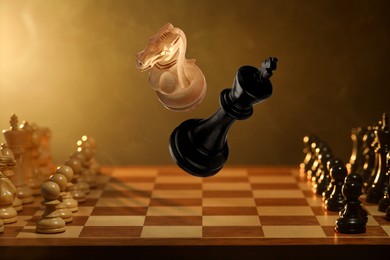 Image of Chess game. White knight and black king in air over chessboard