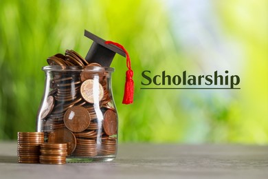 Image of Scholarship. Graduate hat and jar with coins on grey table