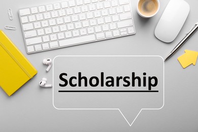 Image of Scholarship. Flat lay composition with computer keyboard and mouse on light grey table. Speech bubble with word