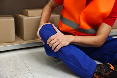 Photo of Accident at work. Injured man on floor in warehouse, closeup