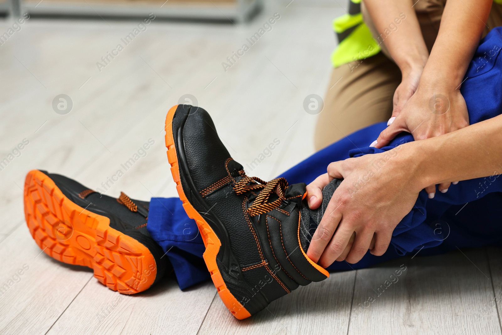 Photo of First aid. Man helping his injured colleague after work accident indoors, closeup