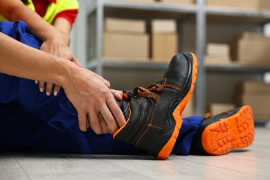 Photo of First aid. Man helping his injured colleague after work accident indoors, closeup