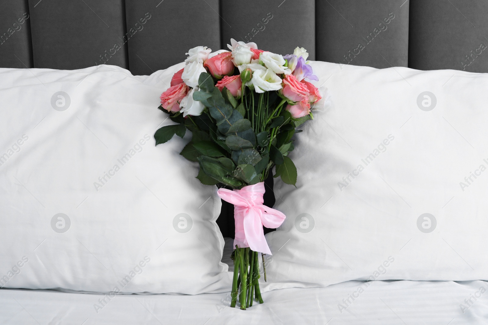 Photo of Wedding bouquet of beautiful flowers and pillows on bed