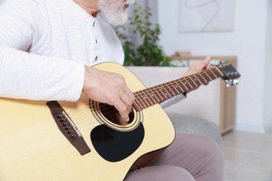 Photo of Relaxing hobby. Senior man playing guitar at home, closeup