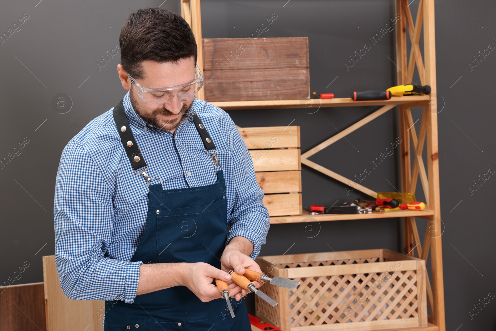 Photo of Relaxing hobby. Man with chisels in workshop