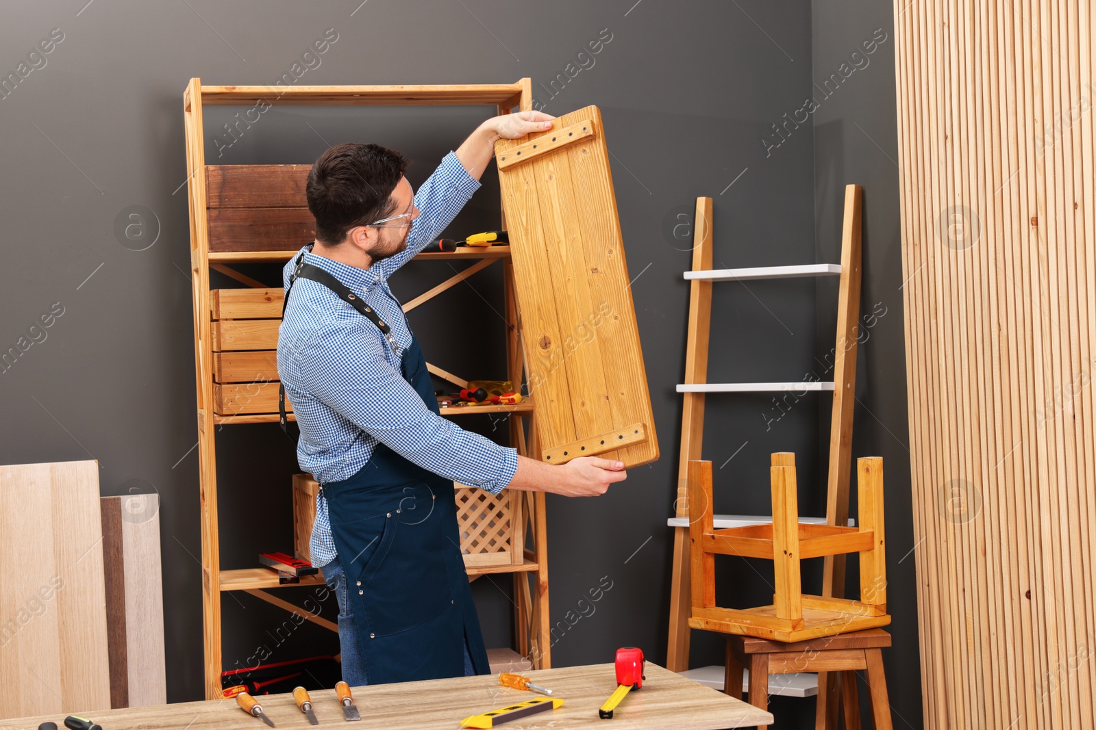 Photo of Relaxing hobby. Man with wooden plank in workshop