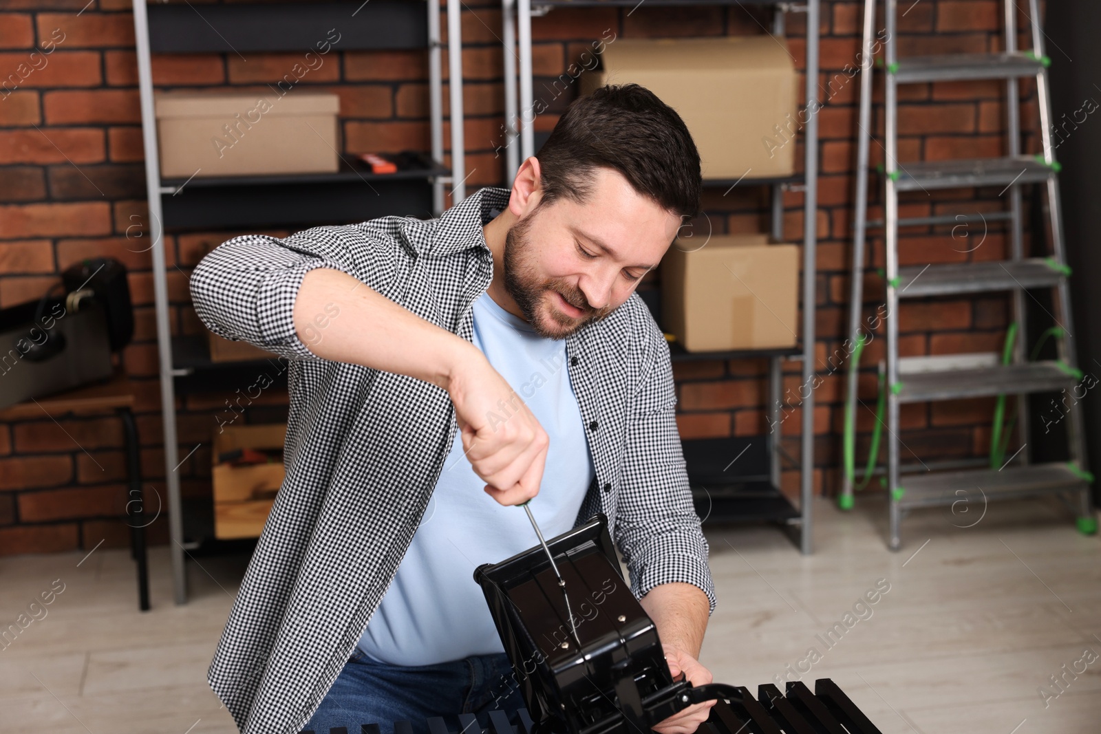 Photo of Relaxing hobby. Man repairing mechanical kitchen scale with screwdriver in workshop