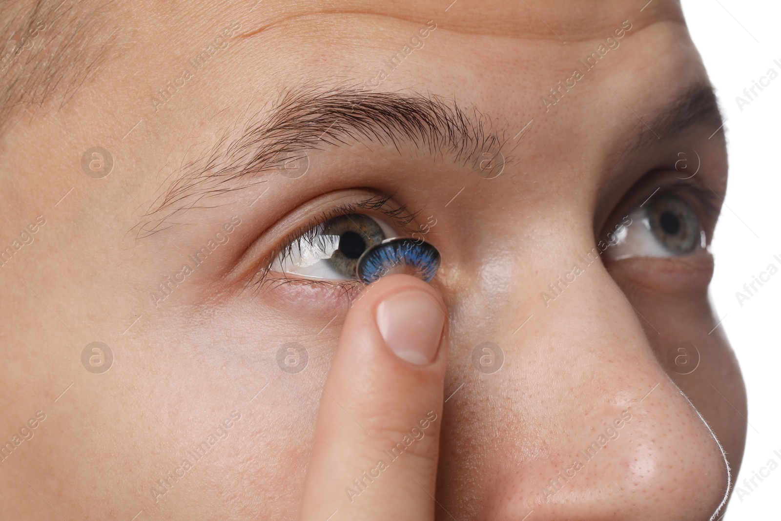 Photo of Man putting color contact lens in his eye, closeup