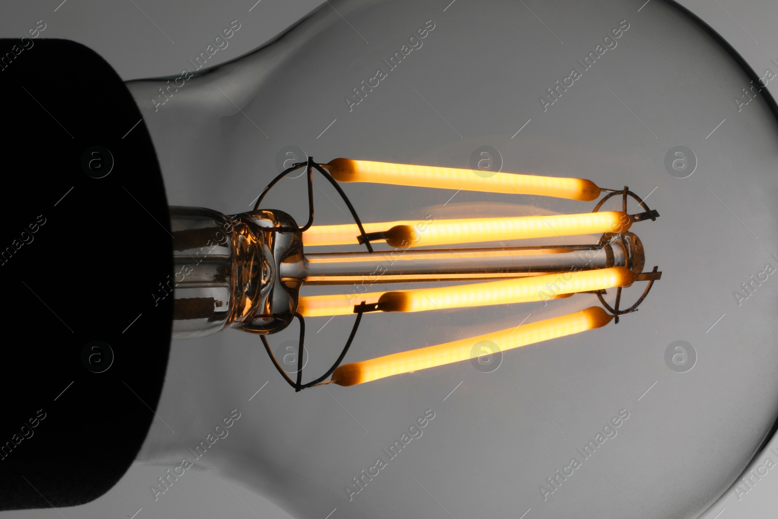 Photo of Glowing light bulb on grey background, closeup