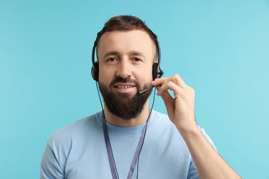 Photo of Technical support call center. Portrait of smiling operator on light blue background