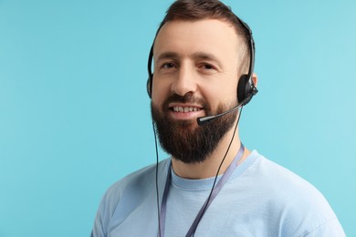 Photo of Technical support call center. Portrait of smiling operator on light blue background