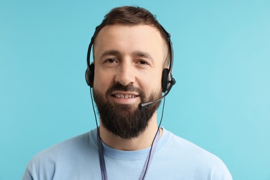 Photo of Technical support call center. Portrait of smiling operator on light blue background